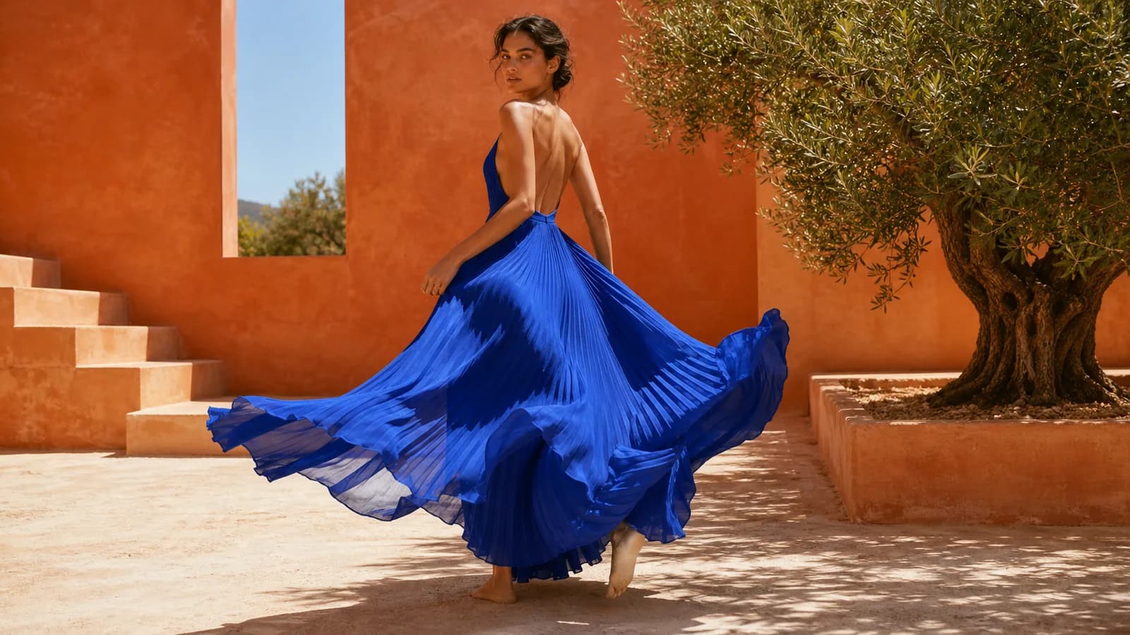 An editorial fashion scene with flowing fabric and a distinctive blue-violet visual language